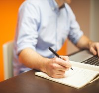 man with notepad and laptop