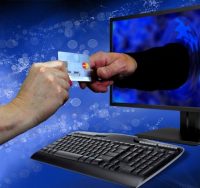 hand offering credit card through monitor